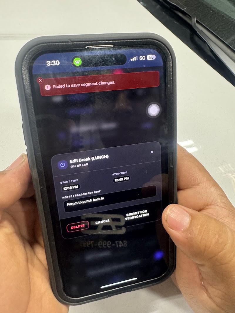 Mobile phone in greasy shop hands showing live error state testing